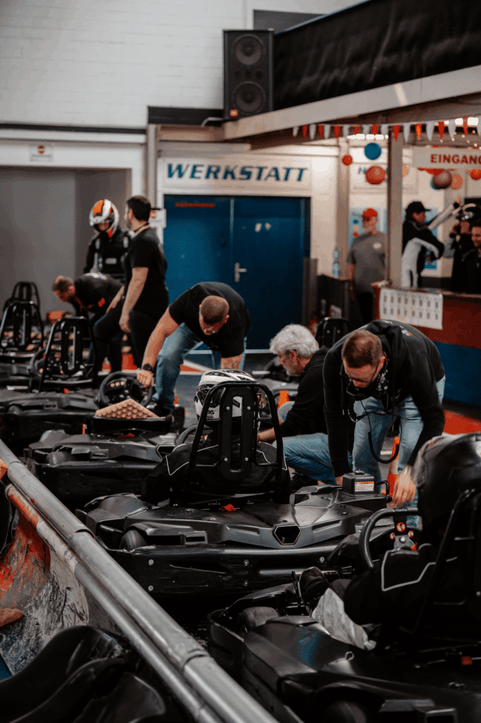 Mitarbeiter des Kartcenter Cologne bereiten Fahrer im Startbereich auf das Kartfahren Köln vor.