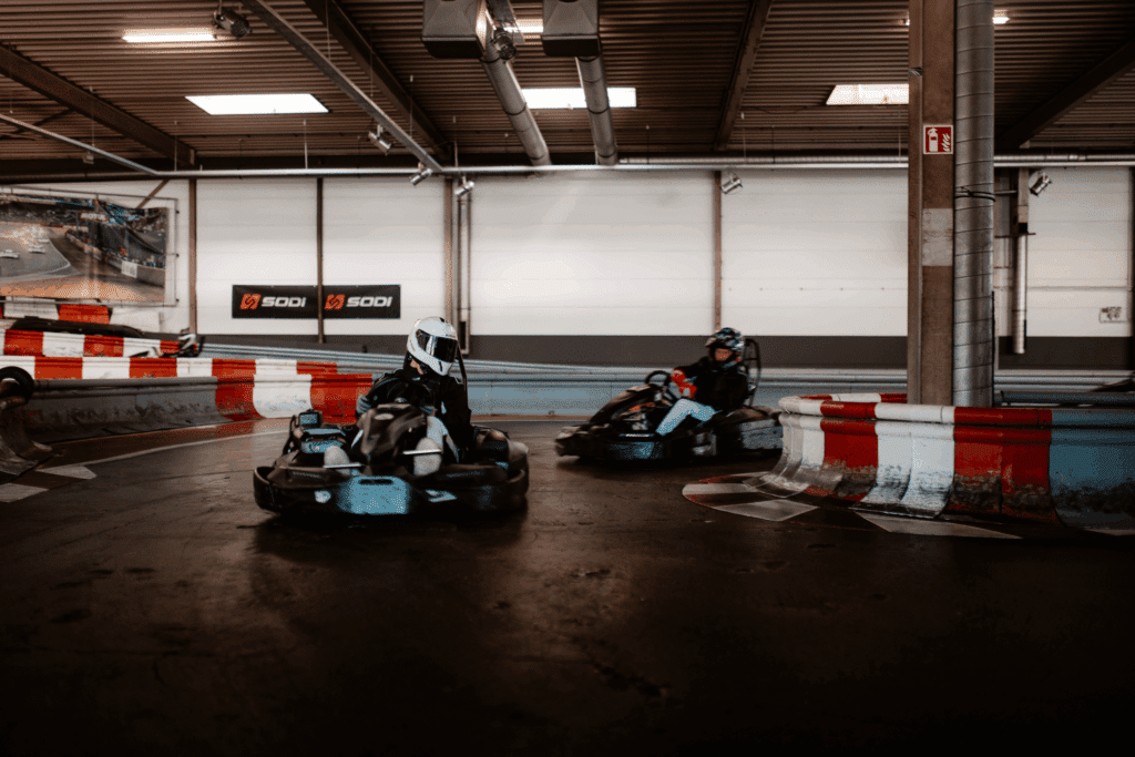 Mehrere Karts fahren in einer Kurve im Wettkampf beim Kartcenter Cologne, Kartfahren Köln.