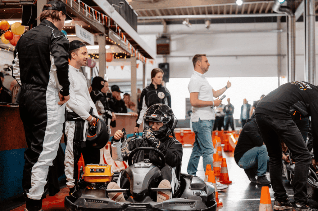 Fahrer in ihren Karts und Mitarbeiter im Startbereich des Kartcenter Cologne, bereit für Kartfahren Köln.