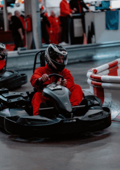Zwei Karts fahren dicht hintereinander im Wettkampf auf der Rennbahn des Kartcenter Cologne beim Kartfahren Köln.